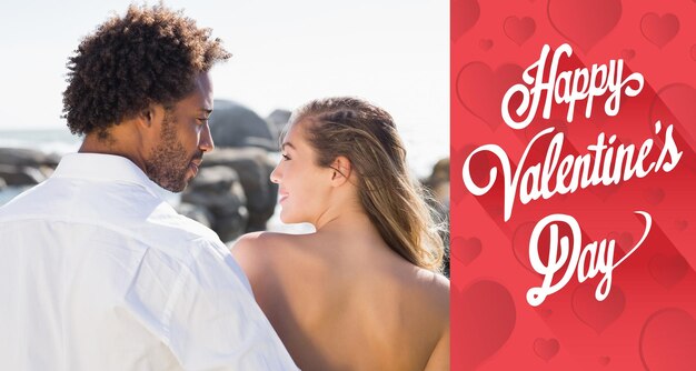 Wunderschönes Paar, das sich an der Küste gegen eine süße Valentinsbotschaft umarmt