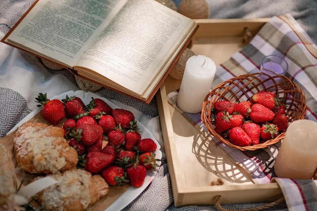 Wunderschönes Picknick mit französischen Erdbeercroissants und offenem Buch mit frischen Beeren