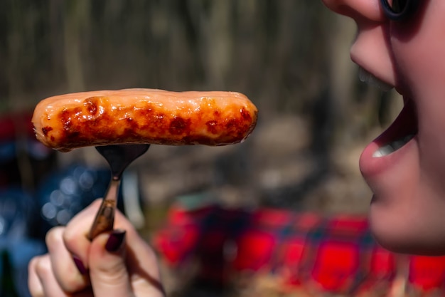 Wurst gebraten auf einem Feuer im Wald im zeitigen Frühjahr