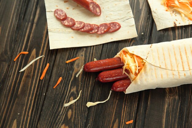 Wurst im Fladenbrot auf hölzernem Hintergrundfoto mit Kopierraum