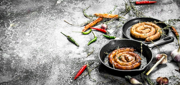 Wurst mit Kräutern und Gewürzen in einer Pfanne.