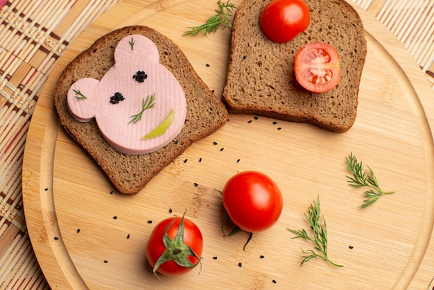 Wurst mit Schwarzbrot und Tomates auf dem hölzernen Hintergrund