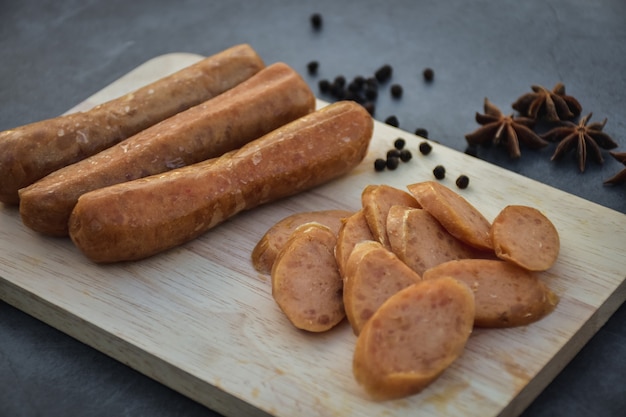 Foto wurst oder guan chiang und kräuter auf dem brett, die gute biersnacks auf dunklem hintergrund servieren.