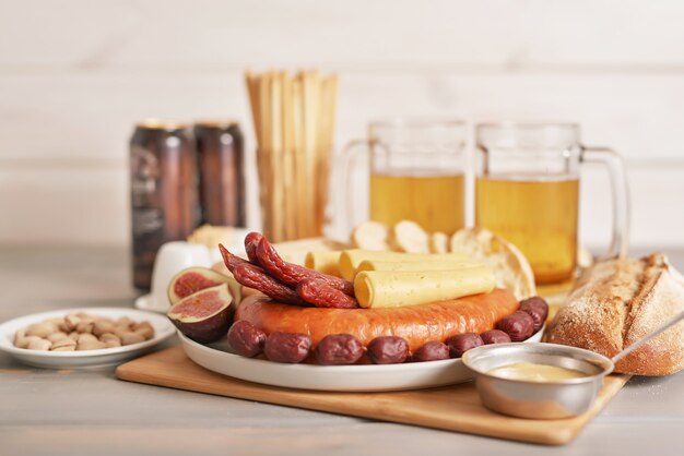 Wurst- und Käsescheiben mit hellem Bier und Pistazien zum Oktoberfest