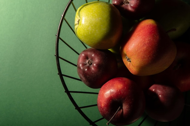 XABasket con jugosas manzanas frescas sobre un fondo verde oscuro Foto de estudio de vista superior