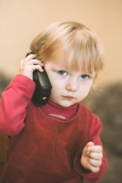 XAbeautiful niña en vestido rojo habla por teléfono móvil