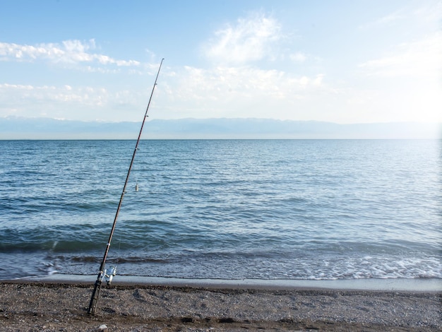 XAFescador pesca de madrugada en la orilla Caña de pescar y spinning Camping