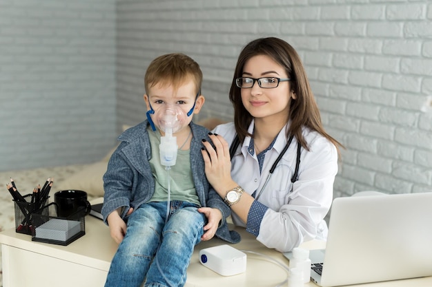 XAMedical médico aplicando tratamiento de inhalación de medicamentos en un niño pequeño con inhalación de asma