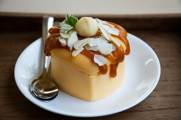 Xarope de caramelo de cobertura de bolo de avelã luxuoso e delicioso serve em bandeja de madeira para pessoas tailandesas comendo bebendo na hora do chá na sala de jantar do café café e padaria restaurante em Bangkok Tailândia