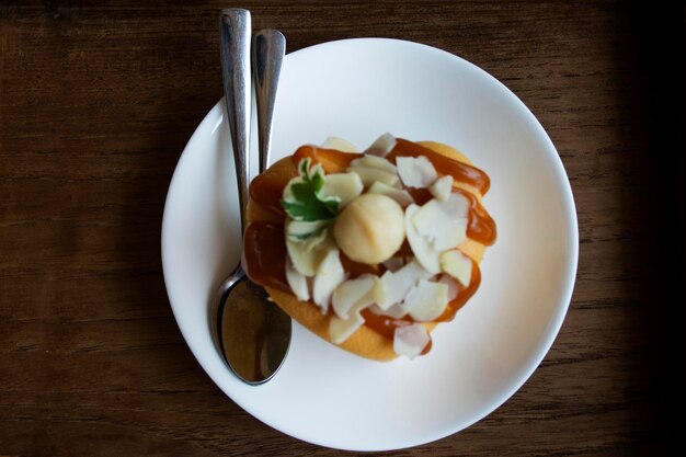 Xarope de caramelo de cobertura de bolo de avelã luxuoso e delicioso serve na bandeja de madeira para pessoas tailandesas comendo bebendo na hora do chá na sala de jantar do café café e padaria restaurante em Bangkok Tailândia