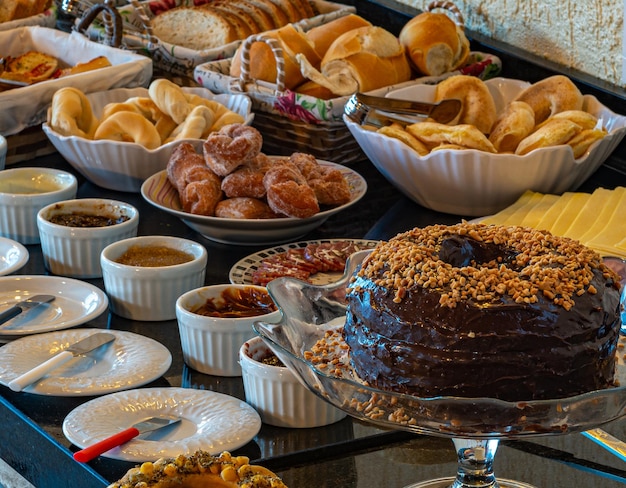 XASuculento desayuno servido con tartas tartas mermeladas bollería queso jamón café leche queso pan y mucho más