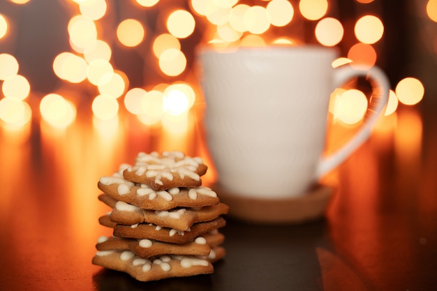 Xícara branca de cacau ou café com chocolate quente e marshmallows e pão de gengibre