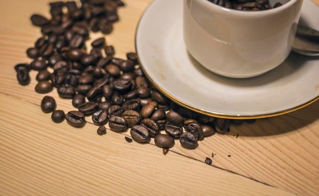 Xícara branca para café e grãos de café na mesa Xícara matinal de café perfumado