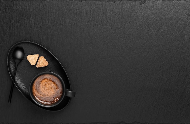 Xícara com café expresso, em um pires dois pedaços de açúcar