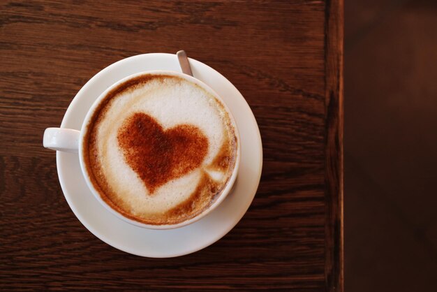 Xícara com café saboroso quente na mesa de madeira vista de perto