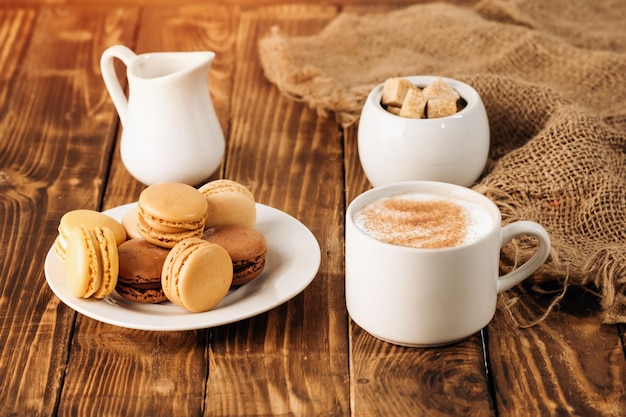 Xícara de açúcar de leite de café e biscoitos em fundo de madeira