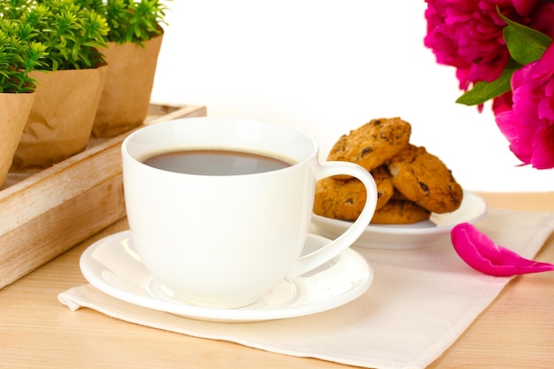 Xícara de biscoitos de café e flores na mesa no café