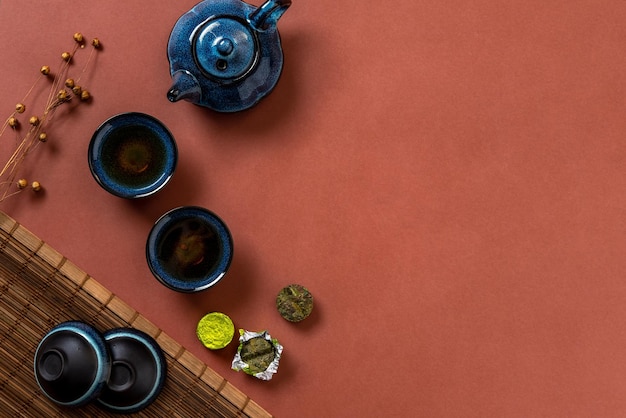 Foto xícara de bule azul de chá e folhas de chá em fundo marrom chá de ervas quente está no bule em cima da mesa copiar espaço