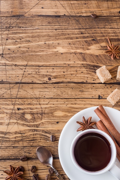 Foto xícara de café, açúcar mascavo e canela com anis em madeira