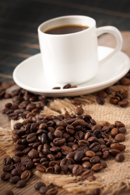 Xícara de café, açúcar mascavo e grãos de café