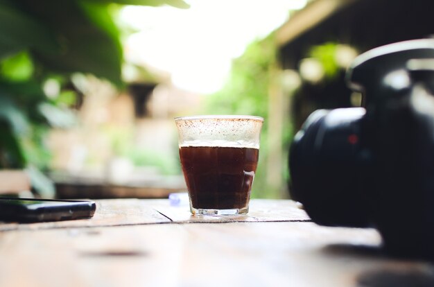 Foto xícara de café americano preto quente na mesa de madeira