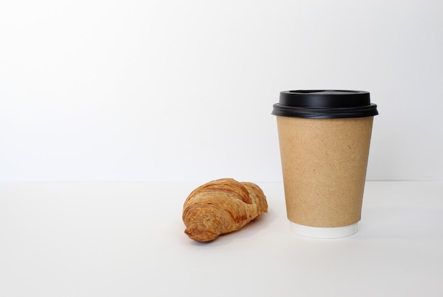 Xícara de café artesanal com croissant em fundo branco Café da manhã francês Vista superior plana