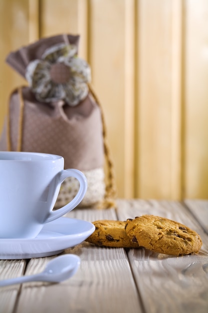 Xícara de café azul com biscoitos e bolsa