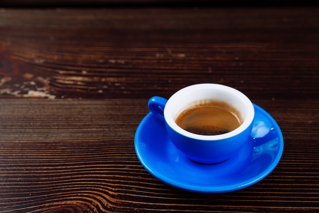 Xícara de café azul em uma mesa de madeira