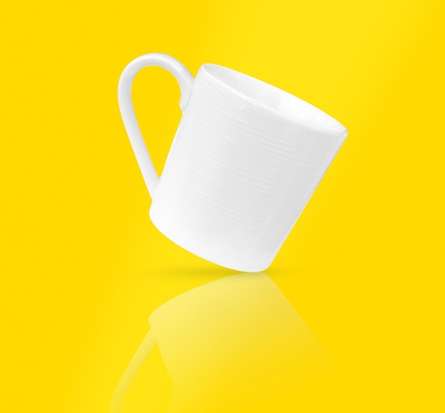 Xícara de café branca em foco suave de fundo amarelo