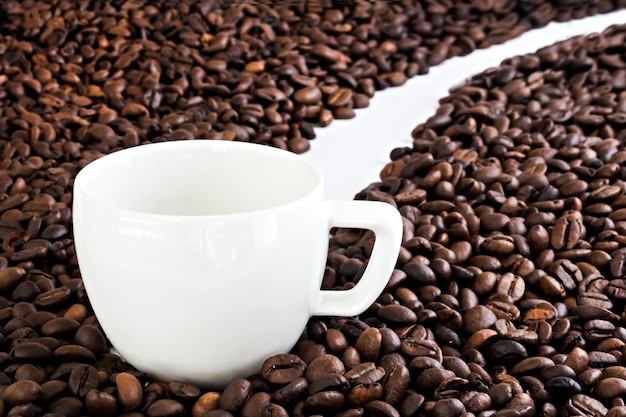 Xícara de café branca no fundo de grãos de café