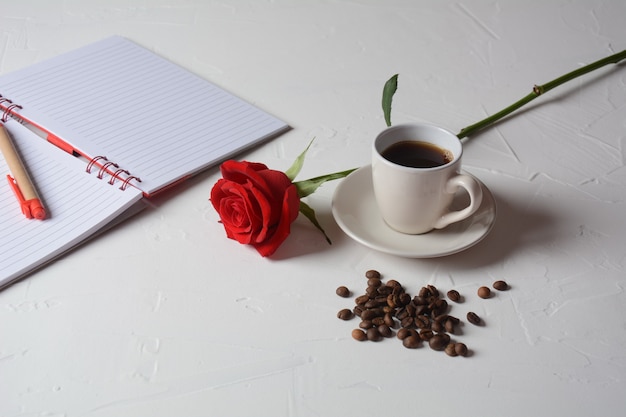 Xícara de café caneta e flores rosas Pausa para o café da manhã