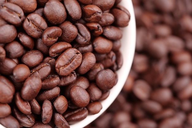 Xícara de café cheia de grãos de café