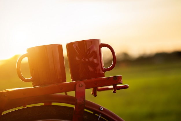 Xícara de café, colocar na bicicleta clássica estilo vermelho do japão à vista do campo de arroz verde