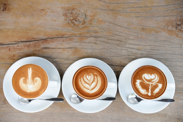 Foto xícara de café com arte de café com leite no menu da mesa de madeira em tempo de pausa para o café.