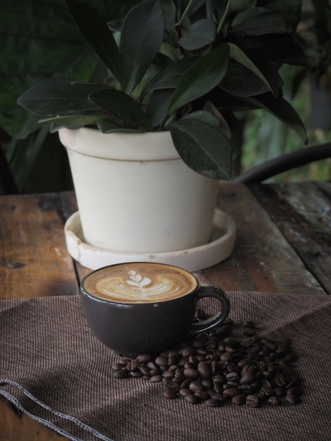 Xícara de café com bela arte Latte. Xícara de café com latte art na mesa de madeira.