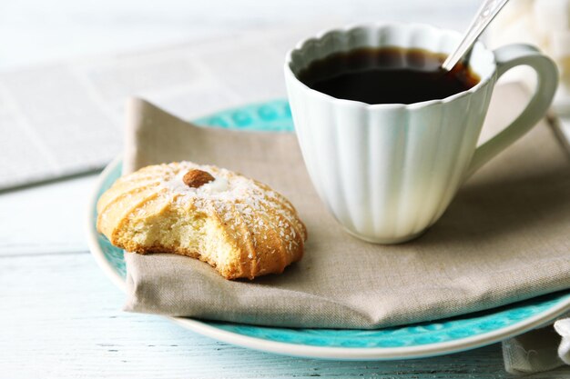 Xícara de café com biscoito saboroso na cor de fundo de madeira