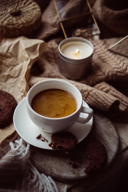 Xícara de café com biscoitos de leite e chocolate no cobertor de lã quente
