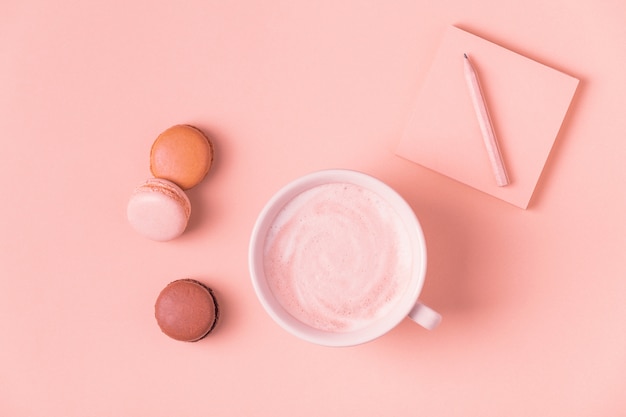 Xícara de café com biscoitos em pastel.