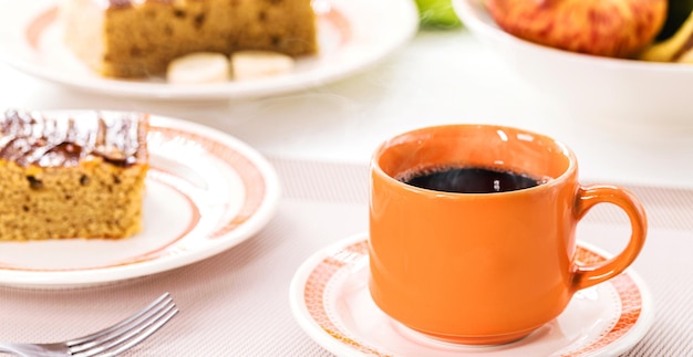 Xícara de café com bolo ao fundo bebida quente típica do Brasil servida em padarias e lanchonetes