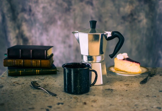 Foto xícara de café com bolo e livros