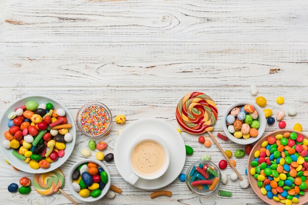 Xícara de café com chocolates e doces coloridos Vista superior no fundo da mesa com espaço para cópia