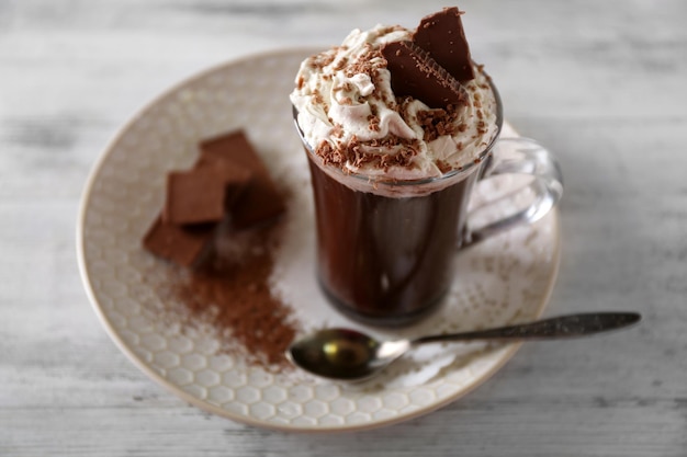 Xícara de café com creme na cor de fundo de madeira