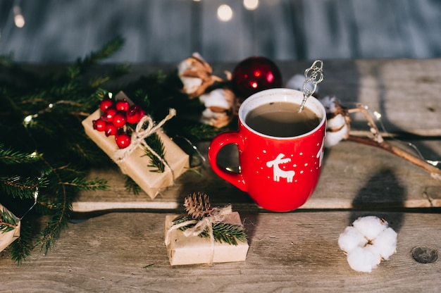 Xícara de café com decorações de Natal na mesa de madeira.