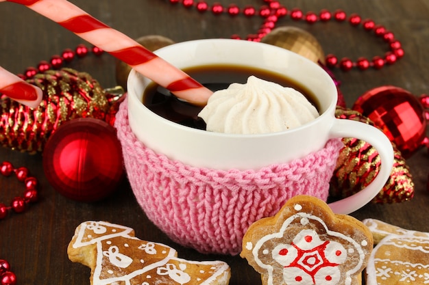 Xícara de café com doçura de Natal em close-up de mesa de madeira