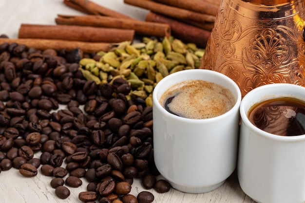 Foto xícara de café com feijão assado, sementes e canela