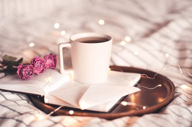 Xícara de café com flores e carta ficar no livro aberto close-up. bom dia. dia dos namorados.