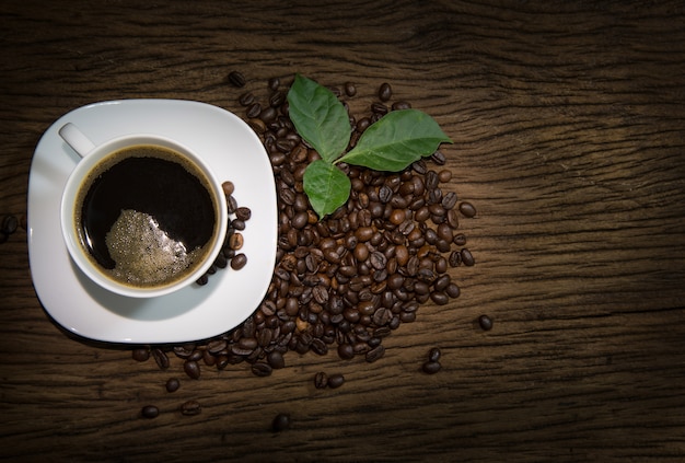 Xícara de café com fumaça no fundo de madeira velha