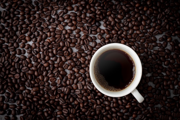 Xícara de café com grãos de café vista de cima da mesa