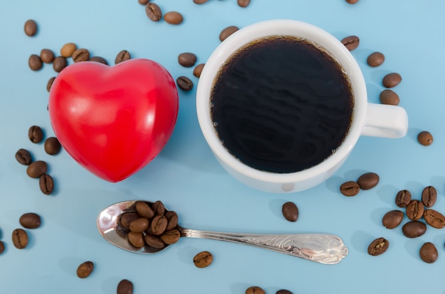 Xícara de café com grãos e coração vermelho