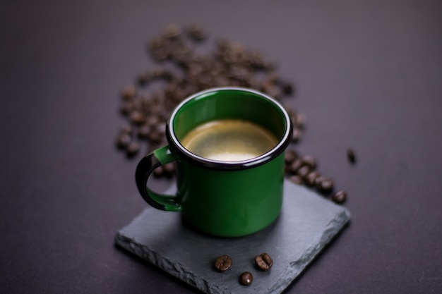 Foto xícara de café com grãos em um fundo escuro